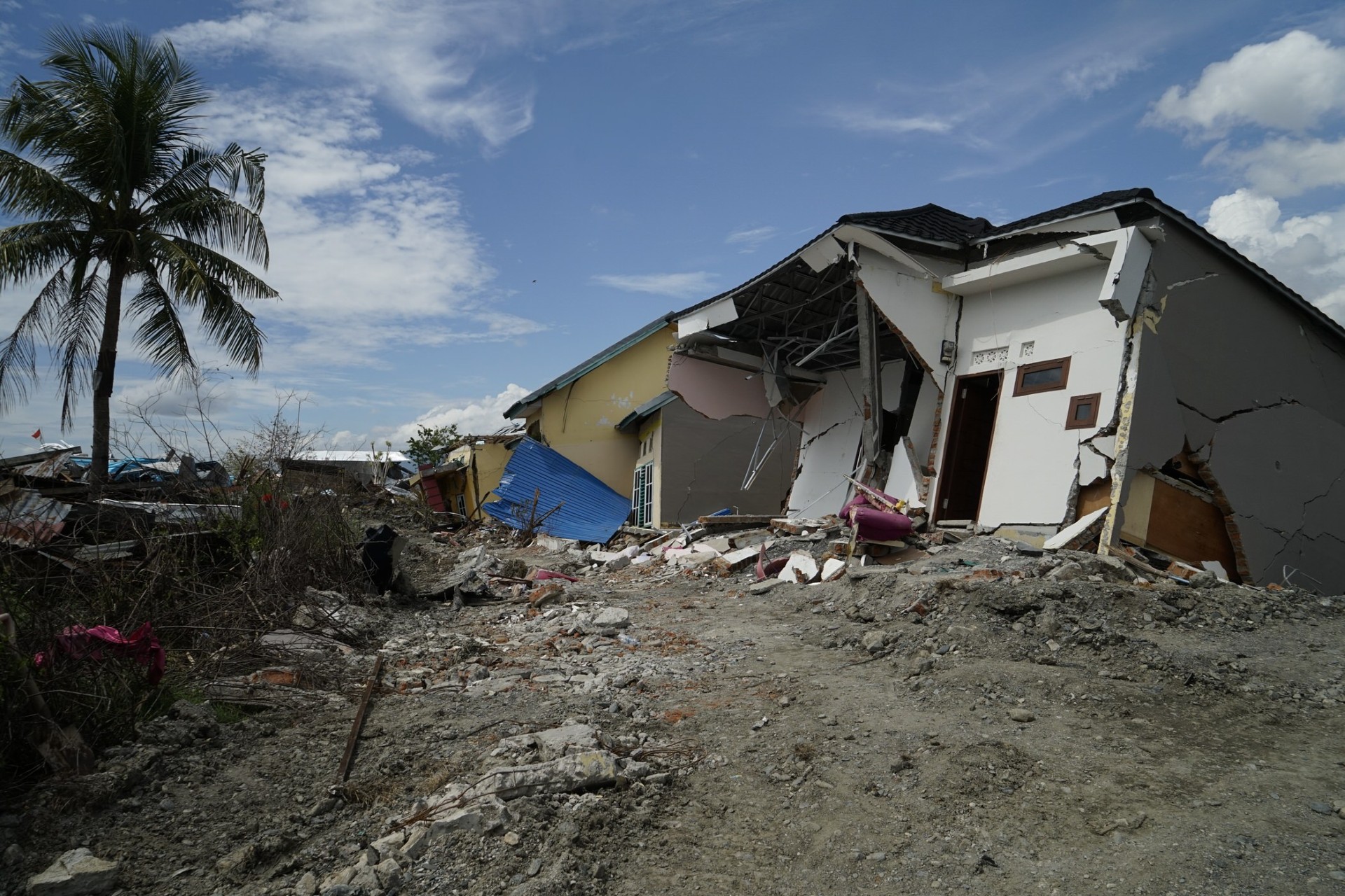 Collapsed buildings showing ground failure after an earthquake, illustrating the effects of soil liquefaction.